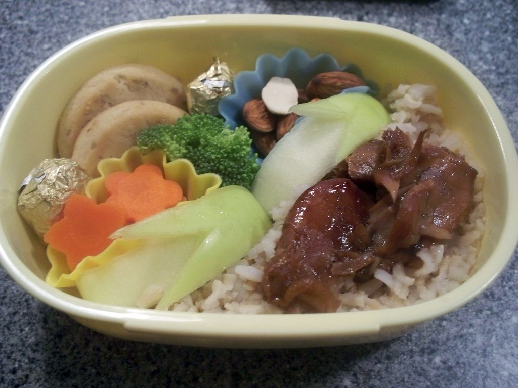 Bento box with rice, meat in sauce, vegetables and nuts
