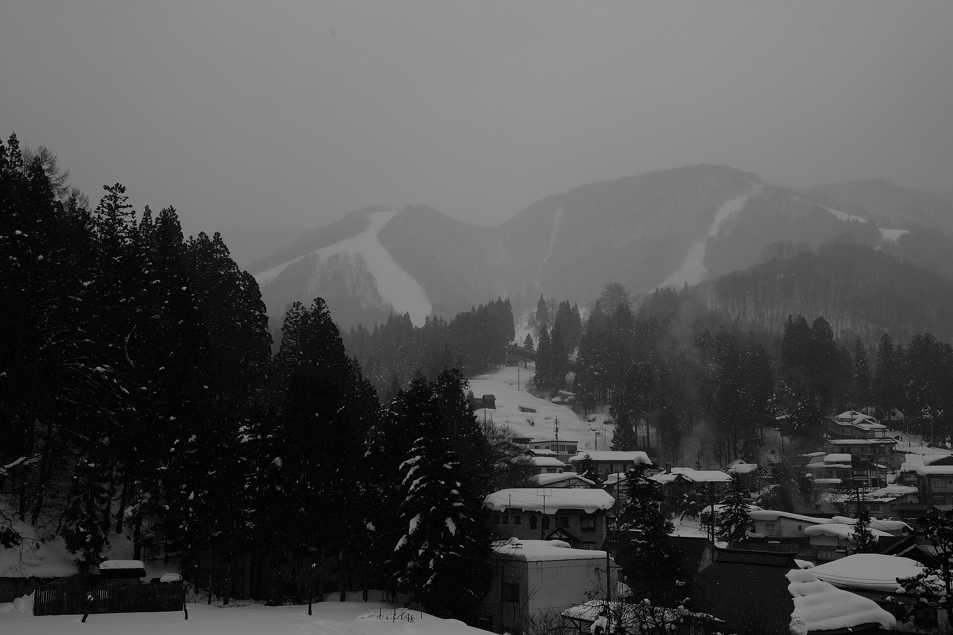 Snow-covered Nozawa Onsen ski village with slope view in winter