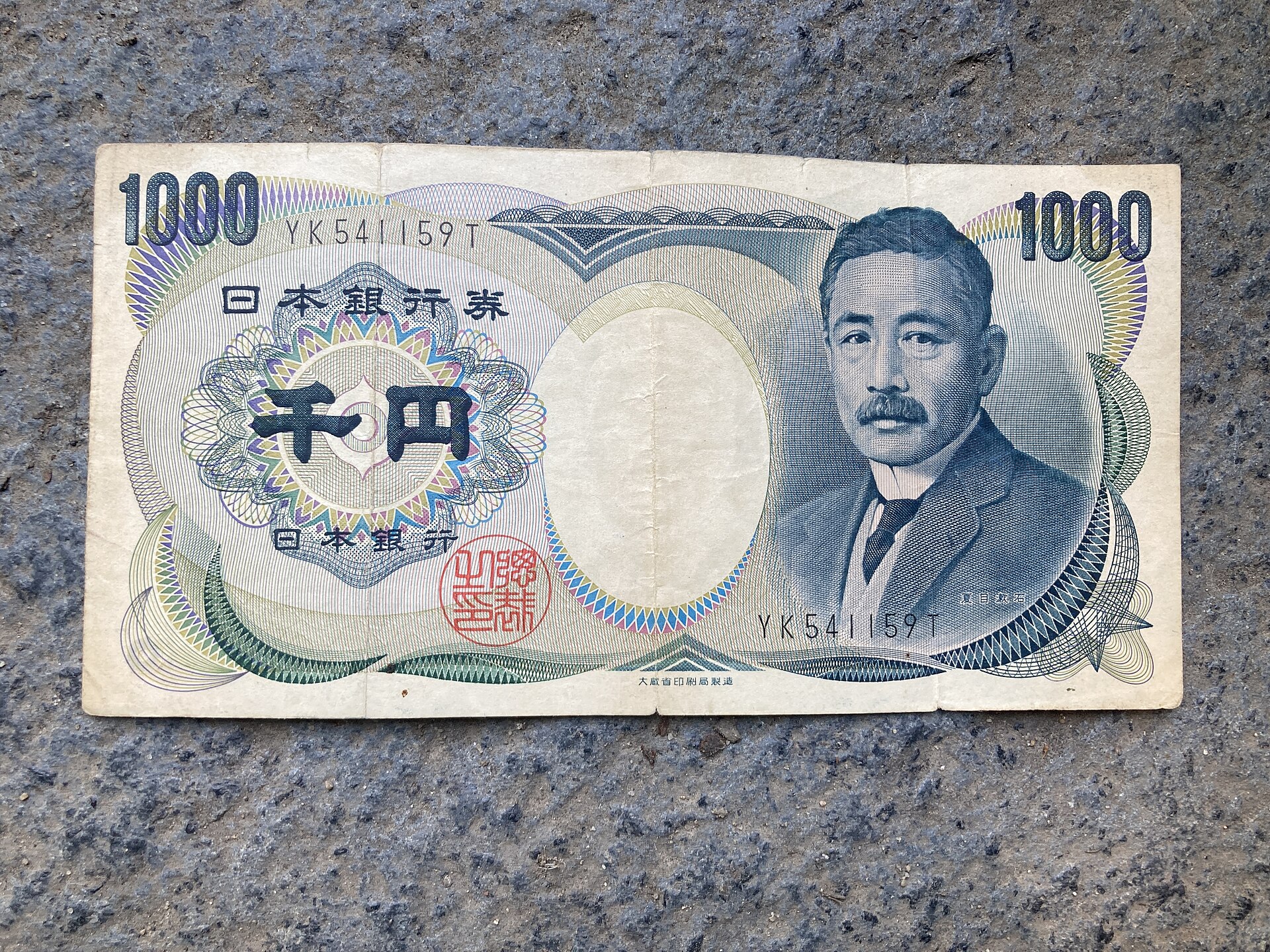 Nahaufnahme einer 1000-Yen-Banknote auf Steinboden