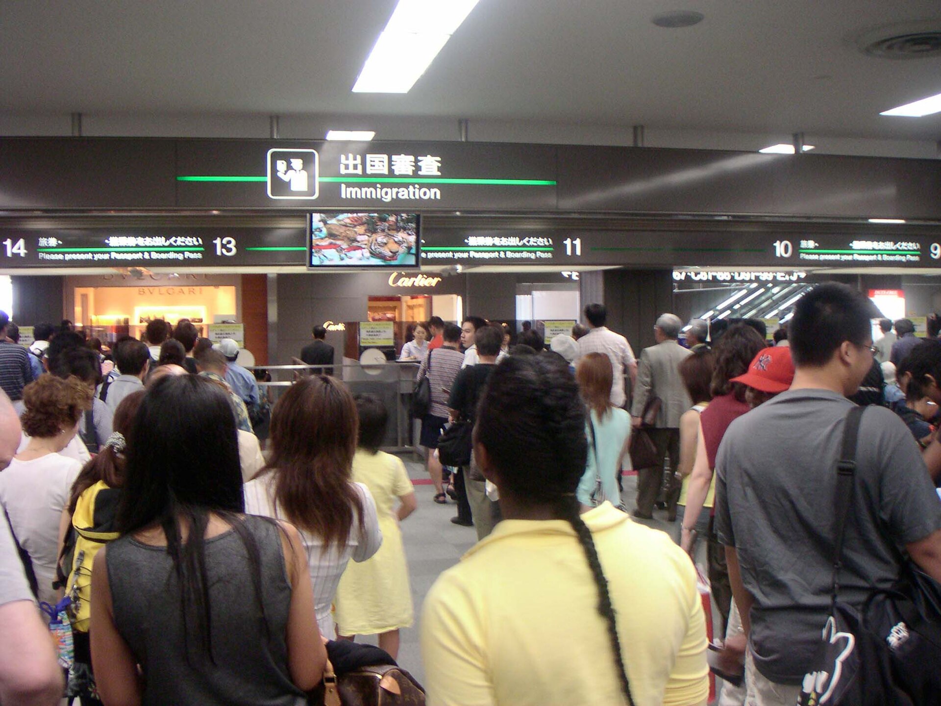 Reisende warten vor der Einreisekontrolle am Flughafen Narita