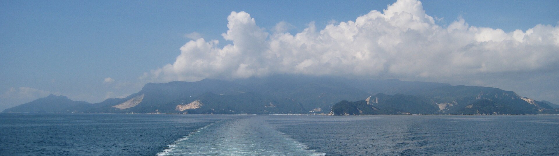 Coastline of Shodoshima seen from a ferry, with wooded mountains beyond