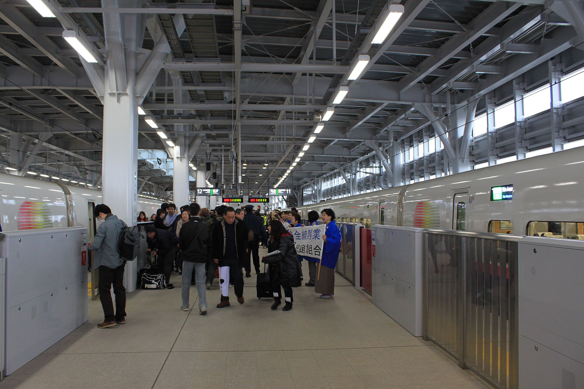 Voller Shinkansen-Bahnsteig mit Reisenden und Gepaeck in Shin-Aomori