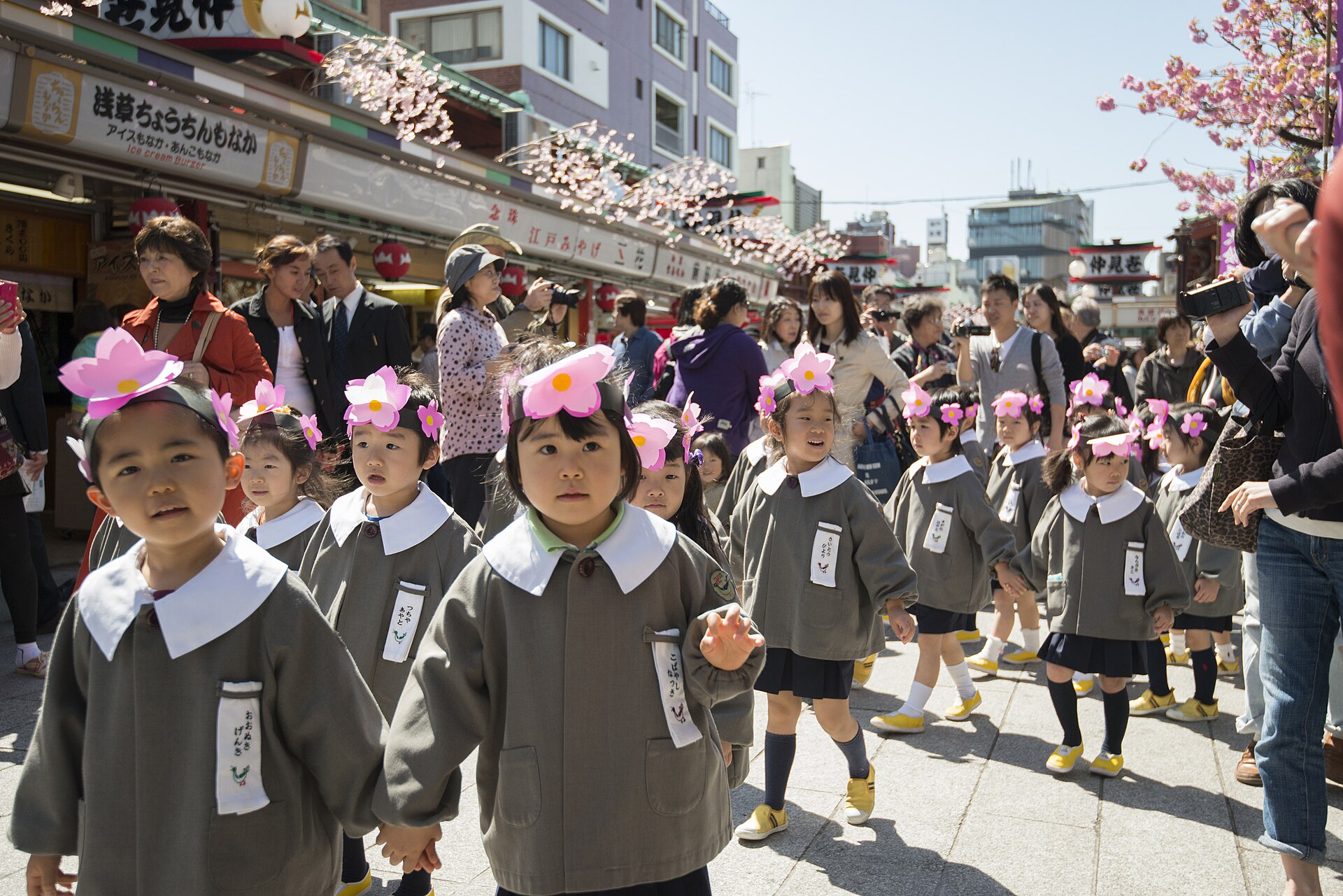 Children wearing pink flower headbands parade through Asakusa during Hana Matsuri, Tokyo.